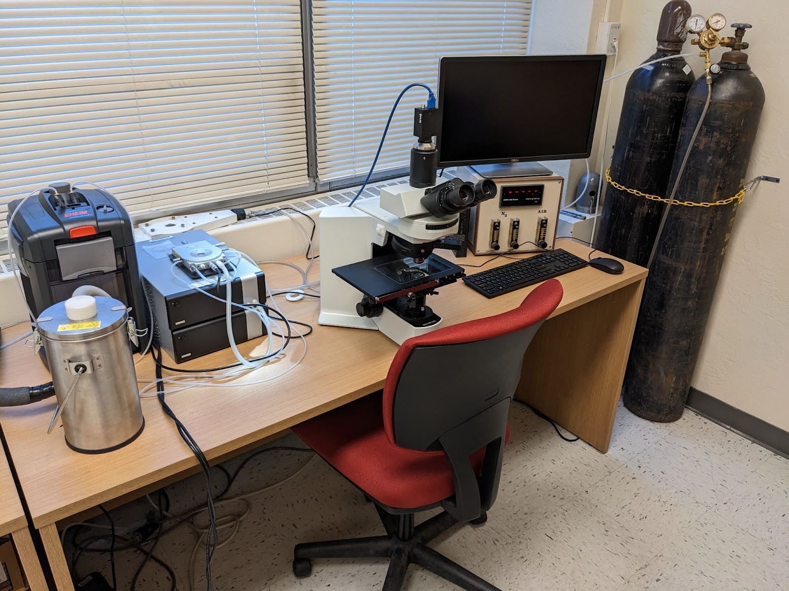 A desk with a microscope and other technology