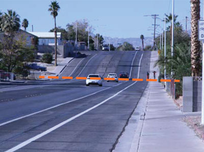 Ground offset across a fault scarp in Las Vegas. Dashed line shows approximate
location where fault crosses the road.